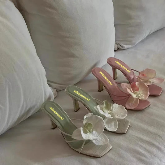 Stylish women's high heels featuring a flower accent on the toe in vibrant colors.